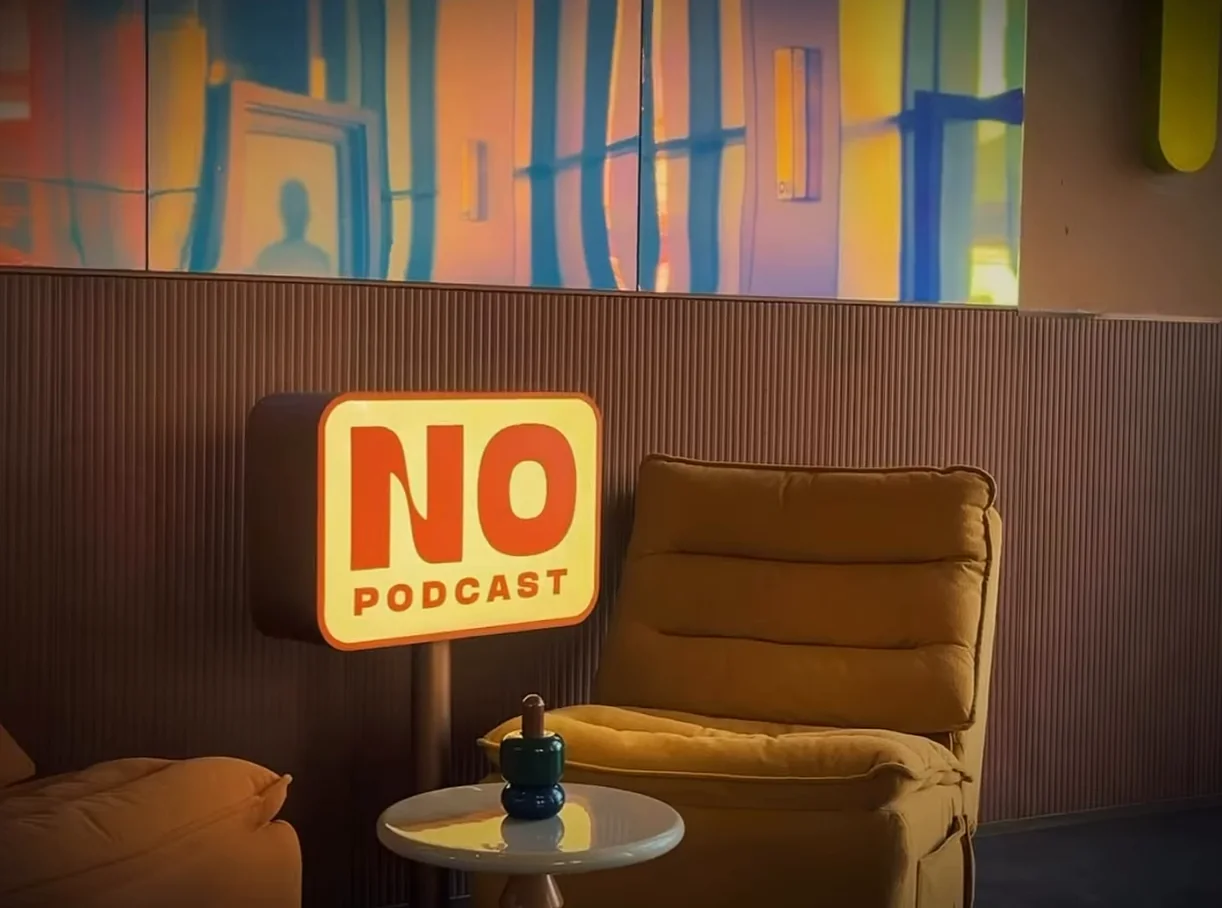 Светящаяся табличка «NO PODCAST» и кресло в углу зала. Кадр ролика @n0marina, 01.09.2026